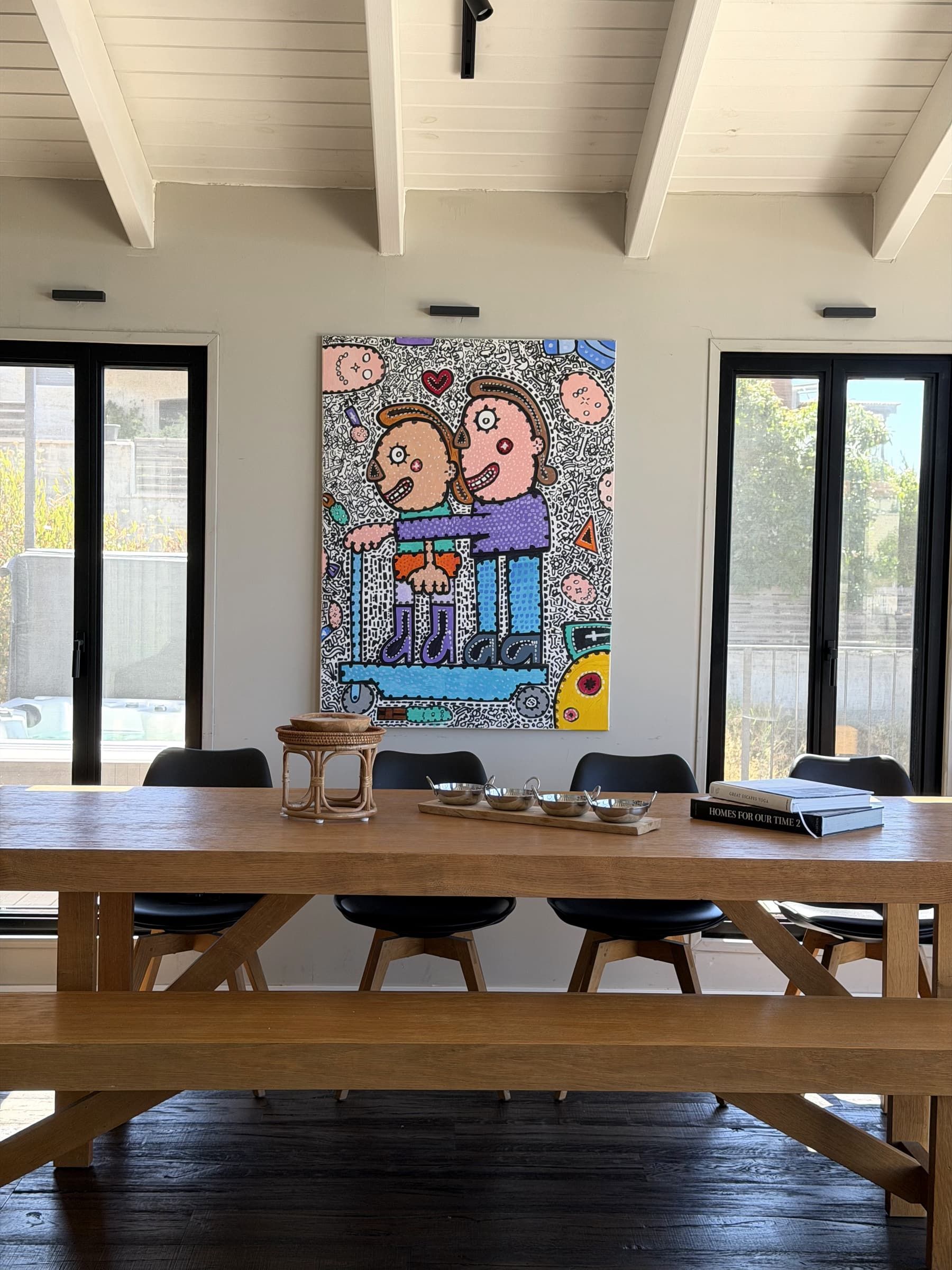 שולחן אוכל ארוך מעץ וציור צבעוני על הקיר